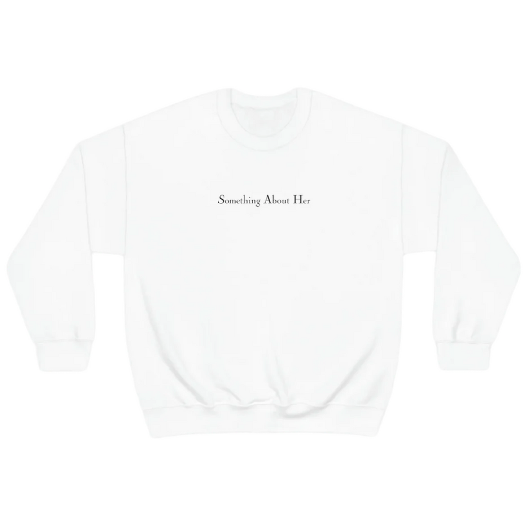 A white crewneck sweatshirt with "Something About Her" embroidered across the chest in black